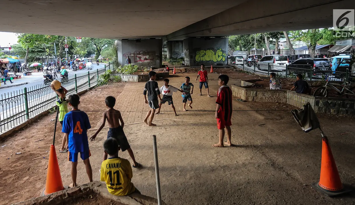 Anak-anak bermain sepak bola di kolong jembatan layang Tanah Abang, Jakarta, Kamis (15/11). Mereka memanfaatkan lahan kosong usai jam pulang sekolah. (Liputan6.com/Fery Pradolo)