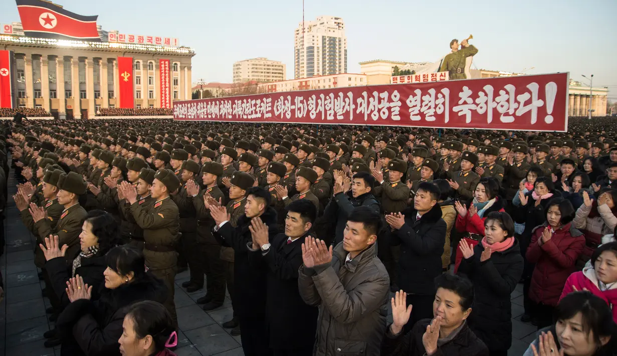 Warga Korea Utara menghadiri sebuah demonstrasi massa untuk merayakan deklarasi Korea Utara di Pyongyang (29/11). Korut menyatakan bahwa negara mereka sudah mencapai targetnya menjadi negara nuklir. (AFP Photo/Kim Won-Jin)