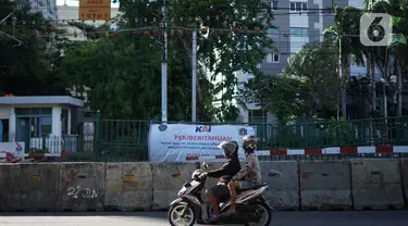Pengendara motor melintas di sekitar perlintasan sebidang dekat Stasiun Palmerah dan Gedung DPR/MPR yang ditutup permanen di Jakarta, Selasa (1/12/2020). Perlintasan itu kini sudah ditutup permanen menggunakan barrier beton. (Liputan6.com/Immanuel Antonius)