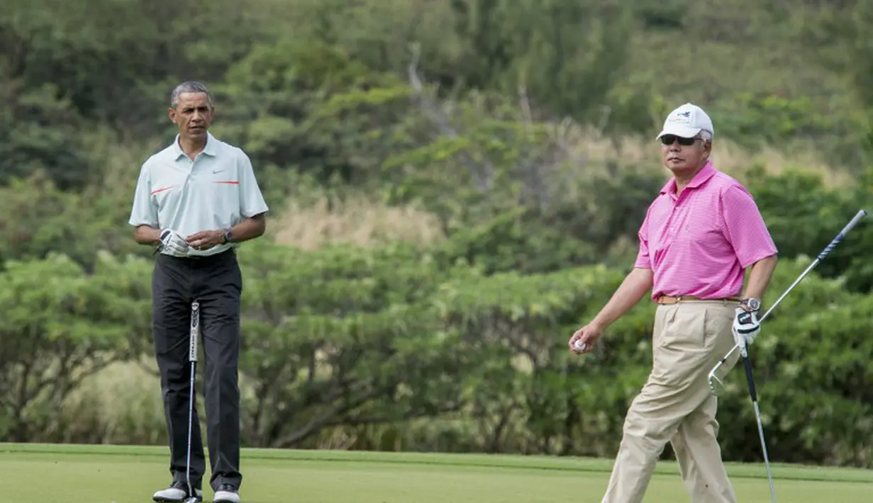 Presiden AS Barack Obama dan PM Malaysia, Najib Razak saat main golf di Hawaii, Rabu (24/12/2014). (AFP PHOTO/Nicholas KAMM)