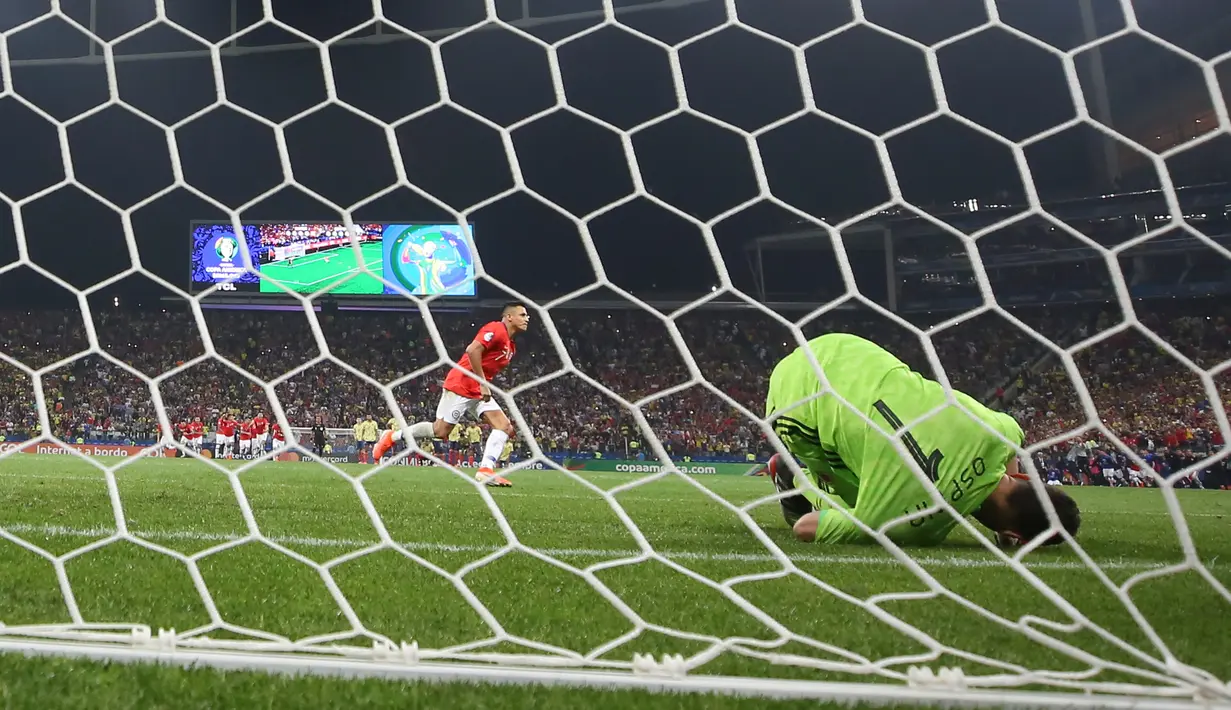 Kiper Kolombia, David Ospina gagal menghadang laju bola tendangan penyerang timnas Cile, Alexis Sanchez pada perempat final Copa America 2019 di Arena Corinthians, Jumat (29/6/2019). Cile melaju ke semifinal Copa America 2019 setelah menundukkan Kolombia, 5-4, lewat adu penalti. (AP/Andre Penner)