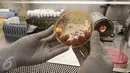 Seorang teknisi kesehatan  menunjukkan bakteri berwarna merah muda di ruang mikrobiologi laboratorium kesehatan RS Husada, Jakarta, Rabu (08/2). Pemeriksaan tersebut untuk mengetahui adanya kuman yang menyebabkan infeksi. (Fery Pradolo/Liputan6.com)