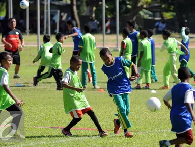 Sejumlah anak bermain bola saat pelatihan singkat di Korem Manokwari, Papua Barat, Selasa (16/8). Jelang perayaan HUT RI ke-71, PT Pertamina mengadakan pelatihan singkat dan laga trofeo di Manokwari. (Liputan6.com/Helmi Fithriansyah)