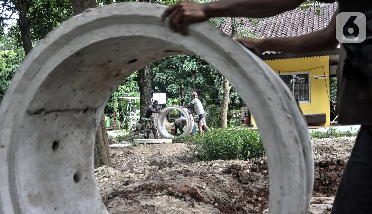Pekerja menyelesaikan pembangunan sumur resapan di RPTRA Meruya Utara, Jakarta, Selasa (25/1/2022). Pembangunan 100 titik sumur resapan ini bertujuan untuk mengantisipasi banjir yang kerap terjadi di wilayah tersebut. (merdeka.com/Iqbal S. Nugroho)