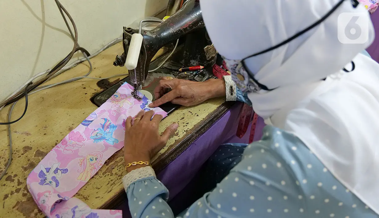 Penjahit sedang menjahit penutup kepala di kawasan Cipinang Cempedak, Jakarta, Kamis (18/6/2020). Kreasi penutup kepala, masker dan Gown yang di inisiasi oleh seorang dokter di RSIA Tambak yang di design untuk khusus tema anak saat masa Pandemi  COVID-19. (Liputan6.com/Herman Zakharia)