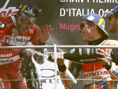 Pebalap Ducati, Danilo Petrucci, bersama Marc Marquez dan Andrea Dovizioso melakukan selebrasi usai menjuarai MotoGP Italia 2019 di Sirkuit Mugello, Minggu (2/6). Petrucci mencatatkan waktu 41 menit 33,794 detik. (AP/Antonio Calanni)