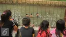 Sejumlah anak melihat temannya bermain di Anak Sungai Ciliwung di Jalan Labu, Kelurahan Mangga Besar, Jakarta, Selasa (17/5). Kondisi air yang mulai jernih dimanfaatkan mereka untuk bermain dan berenang. (Liputan6.com/Gempur M Surya)