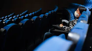 Seorang penonton menunggu dimulainya sebuah film di teater dengan hanya segelintir orang, di bioskop Cineteca Nacional di Mexico City, Rabu (12/8/2020). Setelah ditutup hampir lima bulan akibat Corona, bioskop di ibu kota Meksiko dibuka kembali dengan kapasitas 30%. (AP Photo/Rebecca Blackwell)