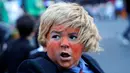 Seorang anak laki-laki berpakaian seperti calon presiden dari Partai Republik, Donald Trump saat acara tahunan Parade Nyack Halloween di Desa Nyack, New York, AS (29/10). (Reuters/Mike Segar)