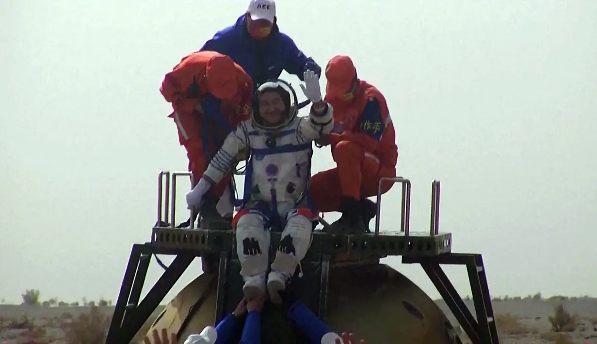 Tangkapan layar menunjukkan astronot China Zhai Zhigang melambai dari atas kapsul pesawat ruang angkasa Shenzhou-13 setelah mendarat di Mongolia Dalam, China, 16 April 2022. (CCTV/AFP)