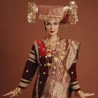 Menarik melihat Luna Maya didandani dengan wastra Nusantara. Dalam foto ini, Luna Maya terlihat mengenakan busana khas masyarakat Padang, lengkap dengan headpiece yang berbentuk rumah gadang. Busana bernuansa merah keemasan ini membuat penampilan Luna Maya yang bule ini sangat ayu. Foto: Instagram.