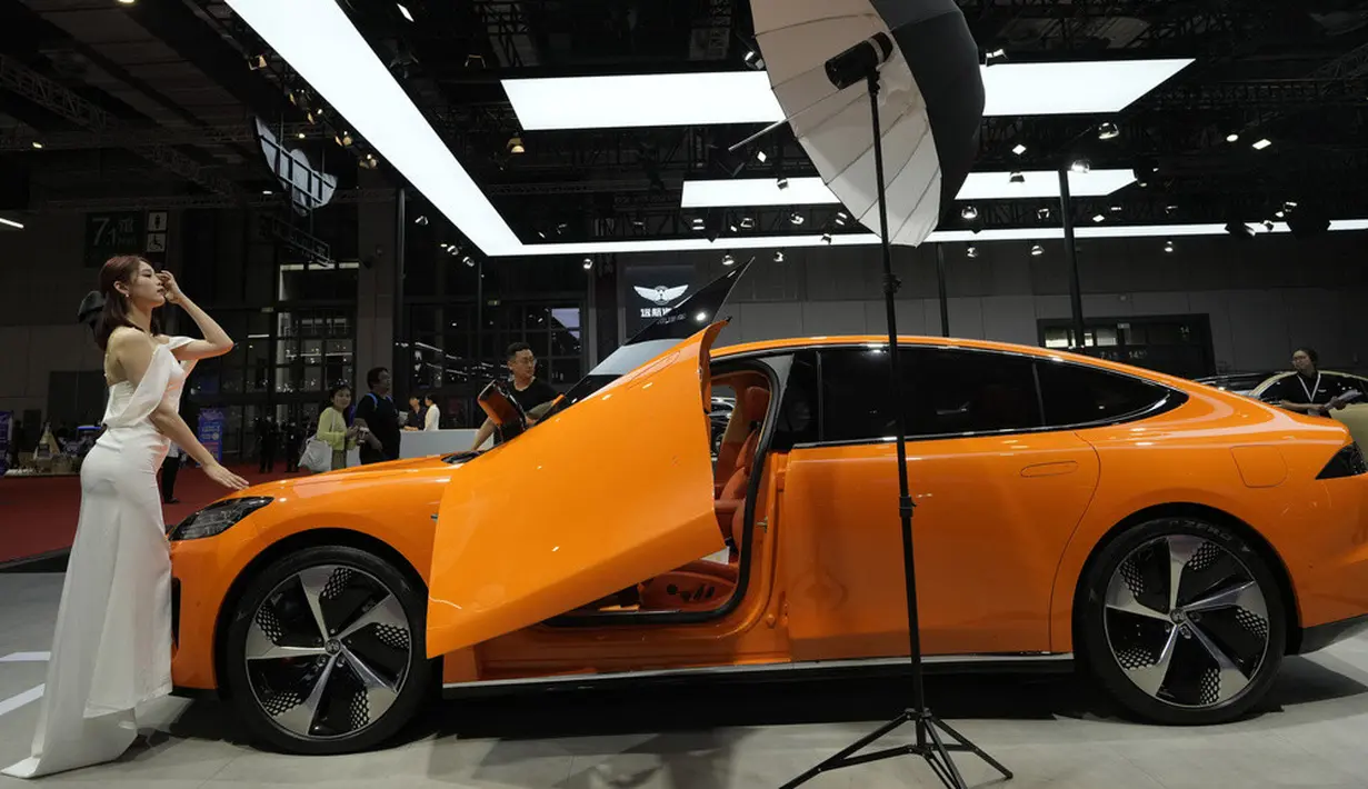 <p>Seorang model berpose dekat Y7 dari pembuat mobil China Yuanhang Motors saat pameran Auto Shanghai 2023. (AP Photo/Ng Han Guan)</p>