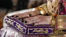 Di momen pelekatan tumbukan halus daun pacar kuku di kuku Lesti Kejora juga terlihat detail aksesori tangan yang digunakannya, berupa cincin pertunangan di jari manis tangan sebelah kiri dan beberapa gelang emas yang dikenakan di kedua tangannya. Foto: Instagram @aldiphoto.