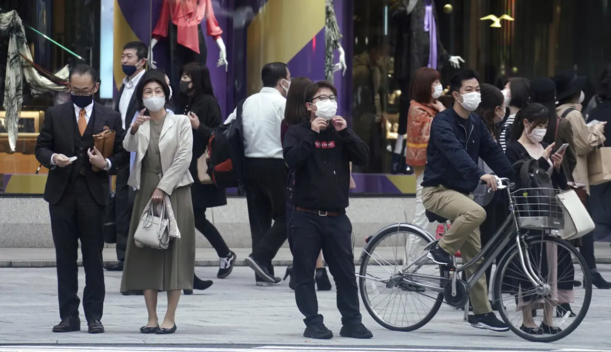 Orang-orang yang mengenakan masker untuk membantu mengekang penyebaran virus corona COVID-19 menunggu untuk menyeberang jalan di Tokyo, Jepang, Rabu (28/10/2020). Tokyo mengonfirmasi lebih dari 170 kasus virus corona COVID-19 baru pada 28 Oktober 2020. (AP Photo/Eugene Hoshiko)