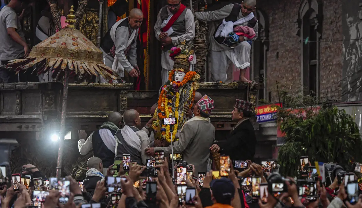 Para pendeta membawa Seto Machindranath, dewa pelindung Nepal, selama festival kereta di Kathmandu (9/4/2022). Seto Machindranath adalah dewa yang disembah oleh dua penganut keyakinan Hindu dan Buddha di Kathmandu. (AFP/Prakash Mathema)