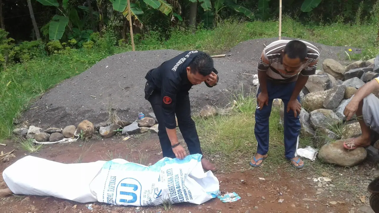 Petugas tengah melakukan pemeriksaan jenazah dalam karung di pantai Cibalong, pantai selatan, Garut