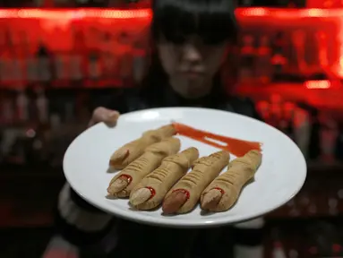 Pelayan menunjukkan potongan jari tangan monster di atas piring di bar V, Beijing, Cina, Jumat (28/11/2014). (REUTERS/Kim Kyung-Hoon)