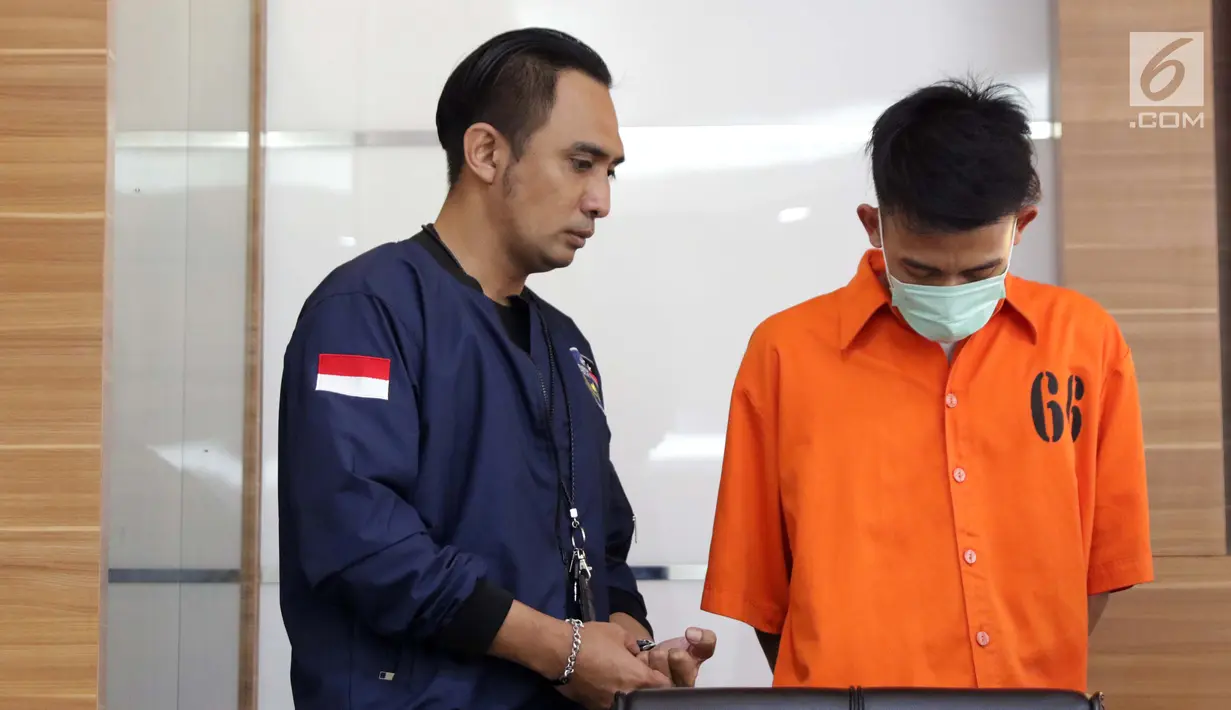 Petugas DirTipidsiber Bareskrim Polri menggiring satu tersangka peretasan situs Kemendagri jelang rilis di Mabes Polri, Jakarta, Jumat (27/9/2019). DirTipidsiber Bareskrim Polri mengungkap dan menangkap tersangka peretasan situs Kemendagri. (Liputan6.com/Helmi Fithriansyah)