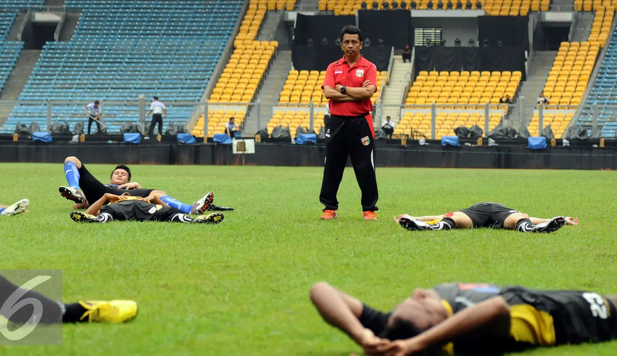 Pelatih tim Mitra Kukar, Jafri Sastra mengawasi langsung relaksasi pemainnya usai berlatih di Stadion GBK Jakarta, Sabtu (23/1/2016). Mitra Kukar akan melawan Semen Padang di final Piala Jenderal Sudirman, Minggu (24/1). (Liputan6.com/Helmi Fithriansyah)