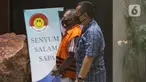 Tersangka kasus dugaan penerimaan gratifikasi bersama Bupati Malang periode tahun 2010-2015 dan periode 2016–2021 Eryck Armando Talla (kiri) digiring petugas usai dihadirkan saat rilis penetapan masa penahanan di gedung KPK, Jakarta, Kamis (30/7/2020). (Liputan6.com/Helmi Fithriansyah)