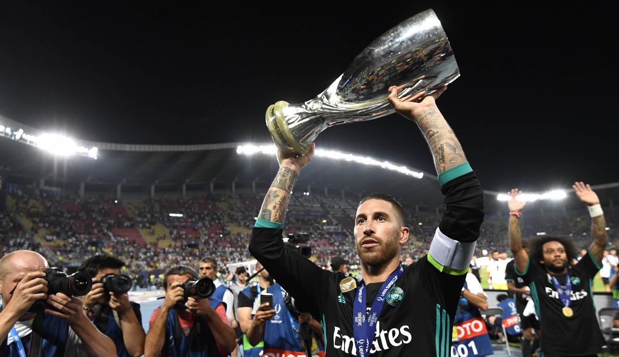 Kapten Real Madrid, Sergio Ramos, mengangkat trofi Piala Super Eropa usai mengalahkan Manchester United di Stadion Philip II, Skopje, Selasa (8/8/2017). Ini merupakan gelar Piala Super Eropa keempat bagi Real Madrid. (AFP/Dimitar Dilkoff)