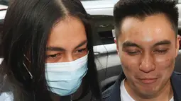 Pasangan selebritis Baim Wong dan Paula Verhoeven saat tiba di polres Jakarta Selatan, Jumat (7/10/2022). Baim mengenakan jaket jeans dilapis kaos warna putih bergambar karikatur anaknya. (Liputan6.com/Herman Zakharia)