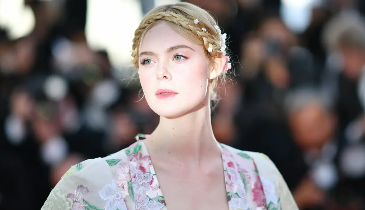 Elle Fanning berpose saat menghadiri screening film "Les Miserables" dalam acara Festival Film Cannes ke-72 di Prancis (15/5/2019). Elle Fanning tampil dengan tatanan rambut kepang milkmaid oleh hairstylist Jenda Alcorn. (AFP Photo/Alberto Pizzoli)