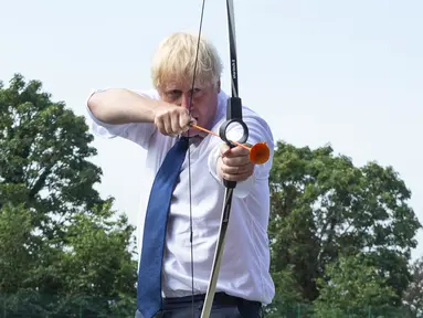 PM Inggris Boris Johnson bermain panahan saat mengunjungi Premier Education Summer Camp di Sacred Heart of Mary Girl's School, Upminster, Inggris, Senin (10/8/2020). Kunjungan Boris untuk melihat persiapan jelang pembukaan kembali sekolah pada September mendatang. (Lucy Young/Pool via AP)