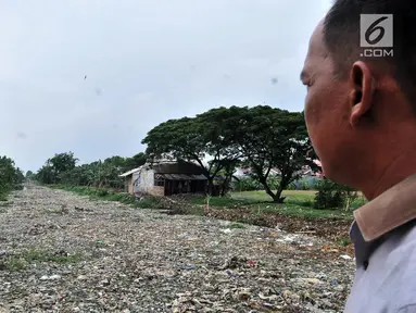 Warga melihat tumpukan sampah yang memenuhi Kali Pisang Batu di Tarumajaya, Kabupaten Bekasi, Jawa Barat, Rabu (9/1). Tumpukan sampah tersebut berasal dari limbah rumah tangga. (Merdeka.com/Iqbal S Nugroho)