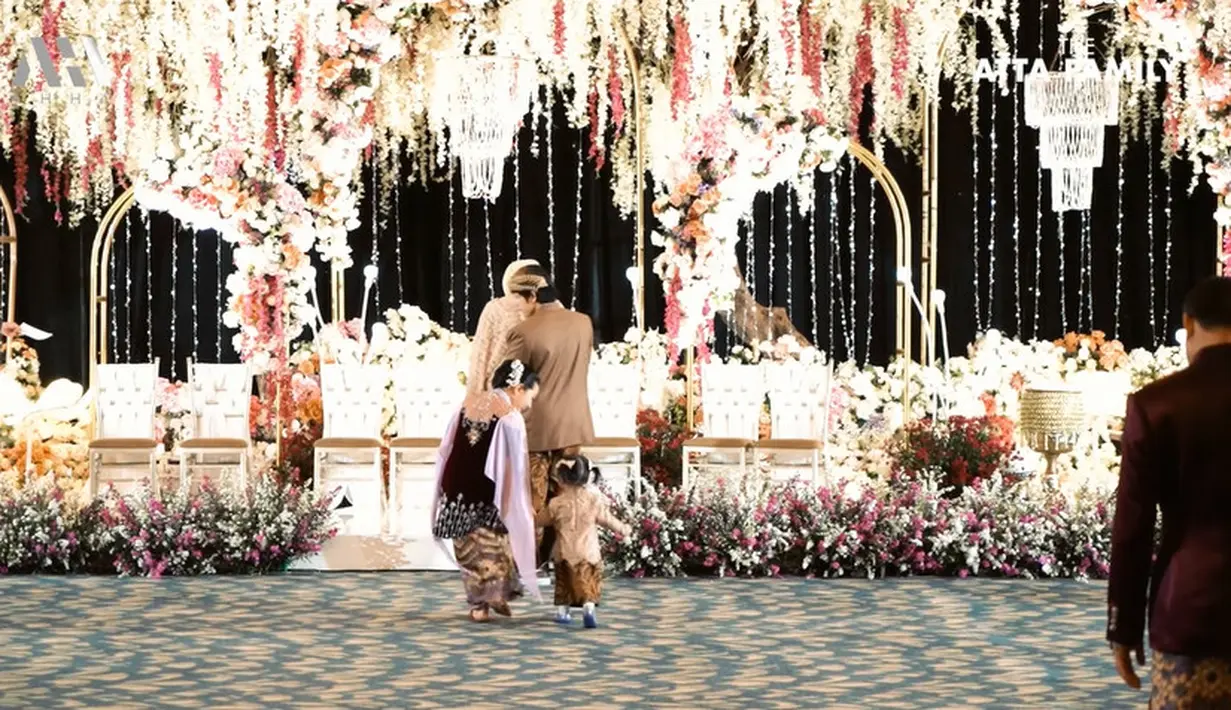Berjalan mengikuti kedua orang tua saat akan duduk di kursi yang telah disiapkan.. Baby Ameena digandeng oleh tantenya, Arsy Hermansyah. [Youtube/AH]
