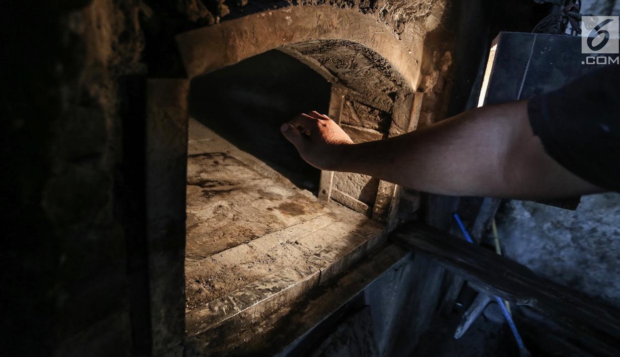 Karyawan mengukur suhu ke dalam tungku menggunakan tangan di Toko Roti GO, Purwokerto, Jawa Tengah, Senin (22/4). Memasuki usia ke 121 tahun, toko roti yang berdiri sejak tahun 1898 ini dibuat mengunakan peralatan tradisional dan tanpa bahan pengawet. (Liputan6.com/Fery Pradolo)