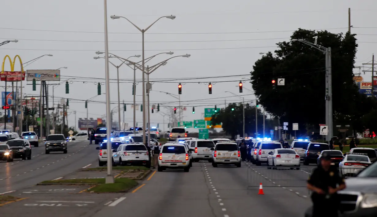 Petugas memblokir jalan di lokasi penembakan petugas kepolisian di Baton Rouge, Louisiana, AS, Minggu (17/7). Tiga polisi tewas dan tiga lainnya mengalami luka-luka saat terjadi penembakan di sebuah jalan. (REUTERS/Joe Penney)