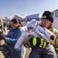 Seorang petugas pemadam kebakaran Polandia menggendong bayi di perbatasan Medyka pada 17 Maret 2022. Lebih dari tiga juta warga Ukraina telah melarikan diri melintasi perbatasan, kebanyakan perempuan dan anak-anak, menurut ke PBB. (Wojtek RADWANSKI/AFP)