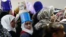 Anak-anak dan perempuan Palestina mengantre untuk makanan buka puasa gratis di dapur amal, Hebron, Tepi Barat, Minggu (20/5). Dapur amal yang dikelola Wakaf Islam itu dinilai sangat membantu dalam mencukupi gizi selama bulan Ramadan. (AFP/HAZEM BADER)