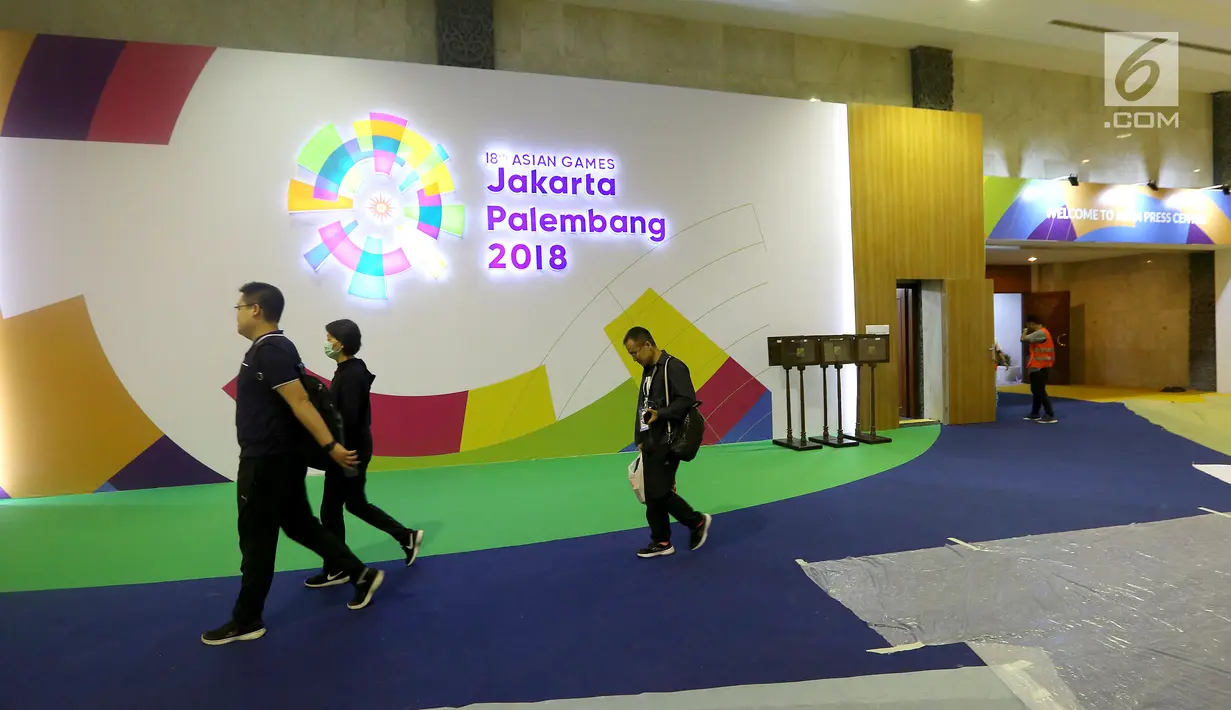 Panitia Inasgoc melintas di loby Main Press Center (MPC) atau media center bagi jurnalis untuk pelaksanaan Asian Games 2018 terus dibangun di Exhibition Hall JCC, Jakarta, Kamis (9/8). MPC akan beroperasi pada 10 Agustus. (Liputan6.com/Fery Pradolo)