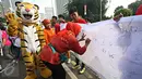 Warga memberikan tanda tangan dalam kampanye bertajuk 'Ayo Hentikan Kejahatan Lingkungan dan Kehutanan' di Jakarta, (20/12). Aplikasi ini bertujuan mengajak masyarakat aktif dalam memberikan laporan kejahatan lingkungan. (Liputan6.com/Immanuel Antonius)