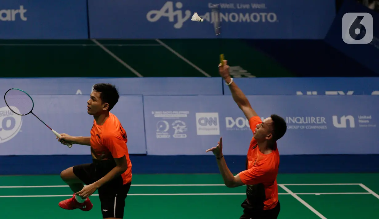 Ganda putra Indonesia, Fajar Alfian/Muhammad Rian Ardianto mengembalikan kok ke arah pasangan Malaysia, Aarron Chia/Soh Wooi Yik pada final bulutangkis beregu putra SEA Games 2019 di Multinlupa Sport Center, Rabu (4/12/2019). Fajar / Rian kalah 17-21 dan 13-21. (Bola.com/M Iqbal Ichsan)