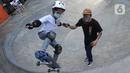 Instruktur melatih seorang anak menggunakan skateboard dengan memakai masker dan face shield di Crooz Shophouse di kawasan Duren Tiga, Jakarta Selatan, Minggu (2/8/2020). Mereka kembali melakukan latihan seminggu dua kali dengan menerapkan protokol kesehatan. (merdeka.com/Arie Basuki)