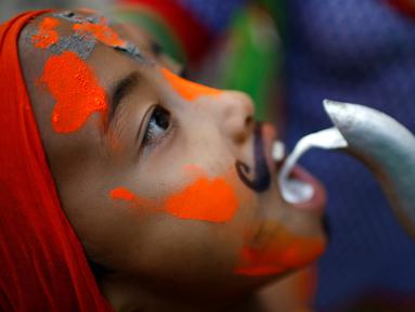 Seorang bocah membuka mulutnya untuk meminum susu saat perayaan Gaijatra Festival atau Festival Sapi di Kathmandu, Nepal, Jumat (19/8). Umat Hindu di Kathmandu merayakan Festival Sapi untuk meminta keselamatan dan kedamaian. (REUTERS/ Navesh Chitrakar)