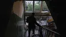Seorang warga membawa barang-barangnya dari sebuah bangunan tempat tinggal yang rusak menyusul serangan rudal Rusia di Kyiv, Ukraina, Senin 15 Juni 2026, di tengah invasi Rusia. (OLEKSII FILIPPOV/AFP)