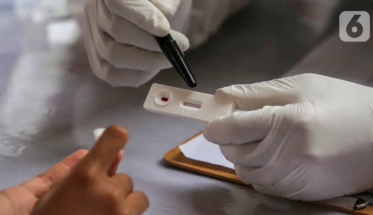 Tenaga medis menunjukkan hasil rapid test yang diselenggarakan Badan Intelijen Negara (BIN) di Kantor Kelurahan Pondok Betung, Tangerang Selatan, Kamis (14/5/2020). Rapid test massal dengan menjemput bola untuk memastikan positif atau tidaknya warga terjangkit Covid-19. (Liputan6.com/Fery Pradolo)