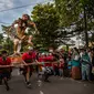 Umat Hindu membawa Ogoh-Ogoh selama pawai di kawasan Pura Segara sehari sebelum Hari Raya Nyepi di Surabaya pada 21 Maret 2023. (AFP/Juni Kriswanto)