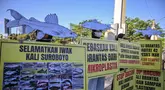 Aktivis dari Ecoton (Pengamatan Ekologi dan Konservasi Lahan Basah) yang mengenakan topeng ikan ikut serta dalam unjuk rasa menyerukan sungai bersih bebas sampah dan limbah industri, serta perlindungan ikan sungai, sebagai bagian dari perayaan Hari Lingkungan Hidup Sedunia di Surabaya, Jawa Timur, Jumat 5 Juni 2026. (JUNI KRISWANTO/AFP)