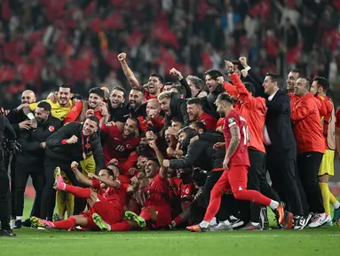 Sejumlah pemain, pelatih, dan ofisial Timnas Turki melakukan selebrasi setelah menang 4-0 atas Latvia pada laga Grup D Kualifikasi Euro 2024 di Konya Buyuksehir Belediye Stadium, Konya, Turki, Senin (16/10/2023) dini hari WIB. Kemenangan ini membuat Turki lolos ke putaran final Euro 2024. (AFP/Ozan Kose)