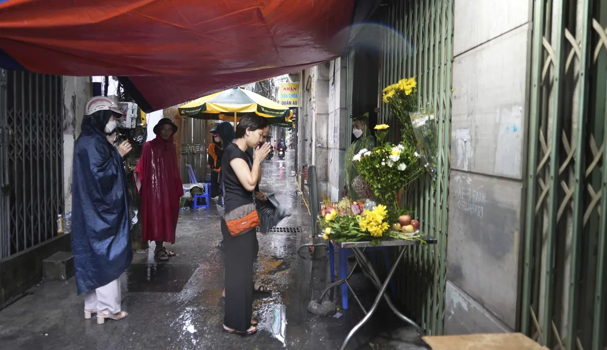 Orang-orang berdoa di depan kuil darurat yang didirikan di depan sebuah gedung yang terbakar di Hanoi, Vietnam, Kamis (14/9/2023). (AP Photo/Hau Dinh)