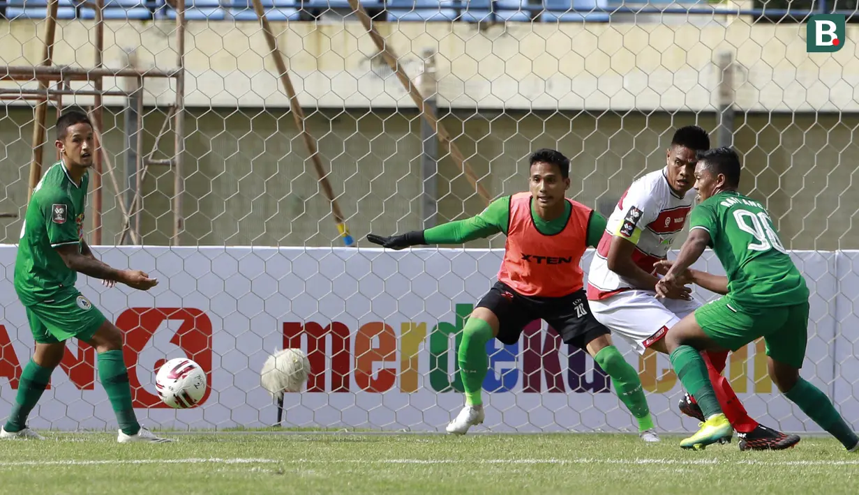 Kiper Madura United, Muhammad Ridho (memakai rompi) bersiap mengantisipasi bola dari ancaman pemain PSS Sleman dalam laga Grup C Piala Menpora 2021 di Stadion Si Jalak Harupat, Bandung, Selasa (23/3/2021). Madura United menang 2-1 atas PSS Sleman. (Bola.com/M Iqbal Ichsan)