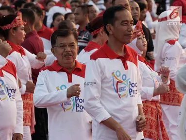 Presiden Joko Widodo bersama Wapres Jusuf Kalla, dan sejumlah pejabat negara menari Poco-Poco dalam rangka pemecahan rekor Guinness World Records di Lapangan Monas, Jakarta, Minggu (5/8). Acara ini diikuti 61 ribu peserta. (Merdeka.com/Iqbal S. Nugroho)