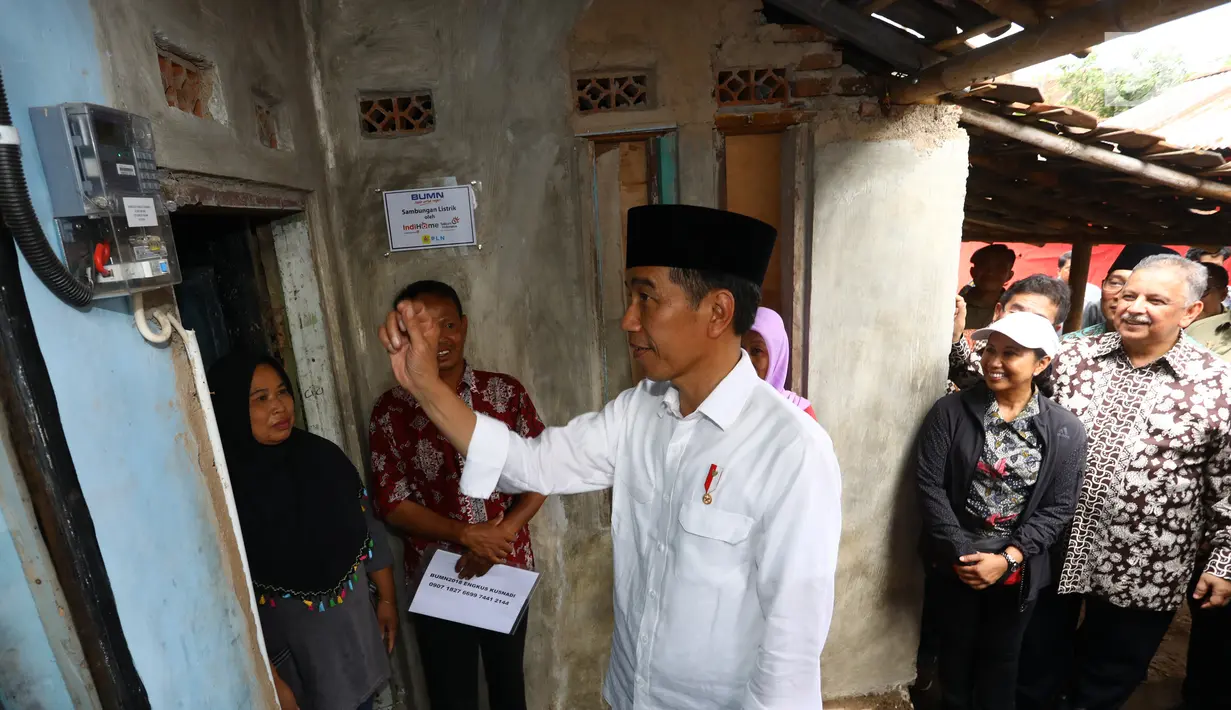 Presiden Joko Widodo saat meninjau rumah yang telah dipasang listrik gratis di Kampung Pasar Kolot, Garut, Jawa Barat, Jumat (18/1). Pemasangan listrik gratis diberikan kepada keluarga prasejahtera. (Liputan6.com/Angga Yuniar)