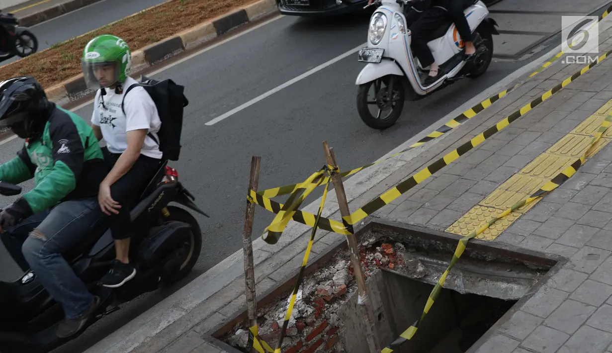 Pengendara melintas di dekat penutup trotoar yang rusak di kawasan Jalan RS Fatmawati, Jakarta, Selasa (14/7/2019). Dua buah penutup trotoar di Jalan RS Fatmawati rusak parah, kondisi ini mengganggu kenyamanan dan membahayakan pejalan kaki, terutama pada malam hari. (Liputan6.com/Helmi Fithriansyah)