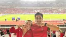 Sebagai pasangan yang dikenal kerap tampil serasi, Donna Agnesia memilih jaket Timnas merah, sementara sang suami, Darius Sinathrya, mengenakan jersey Timnas dengan aksen list hijau. Pilihan outfit mereka menunjukkan kombinasi sporty yang tetap modis. [@dagnesia].